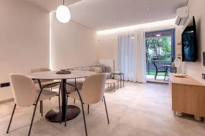 a dining room and living room with a table and chairs at Phaedrus Living Athens Luxury Residences Ivory in Athens
