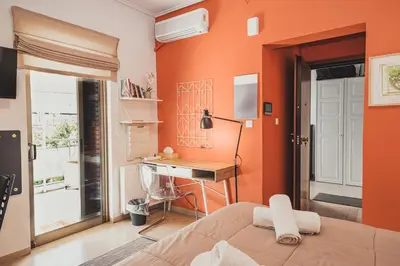 a bedroom with orange walls and a desk and a bed at Tsakalof 10 Veranda by Zeussuites in Athens