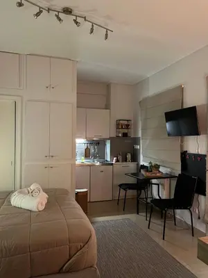 a bedroom with a bed and a table and a kitchen at Tsakalof 10 Veranda by Zeussuites in Athens