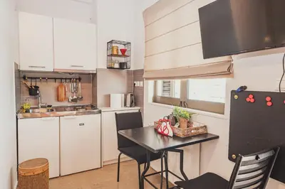 a kitchen with a table and a black refrigerator at Tsakalof 10 Veranda by Zeussuites in Athens