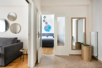 a living room with a couch and a mirror at Helios Apartment by A&A Residences in Athens