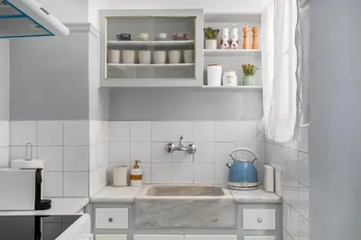 a kitchen with a sink with a blue tea kettle at Helios Apartment by A&A Residences in Athens