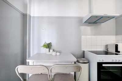 a kitchen with a white table and two chairs at Helios Apartment by A&A Residences in Athens