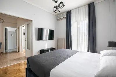 a bedroom with a bed and a large window at Helios Apartment by A&A Residences in Athens