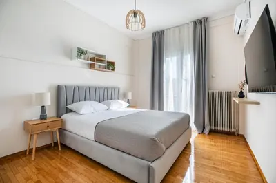 a bedroom with a bed and a large window at Helios Apartment by A&A Residences in Athens