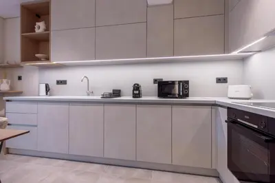 a kitchen with white cabinets and a microwave at Phaedrus Living Athens Luxury Residences Sands in Athens
