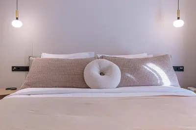 a donut pillow sitting on top of a bed at Phaedrus Living Athens Luxury Residences Sands in Athens
