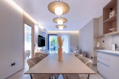 a kitchen and dining room with a wooden table and chairs at Phaedrus Living Athens Luxury Residences Sands in Athens