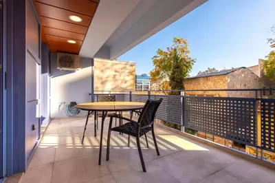 a patio with a table and chairs on a balcony at Phaedrus Living Athens Luxury Residences Sands in Athens
