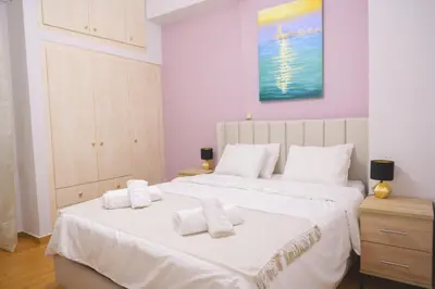 a bedroom with two beds with white sheets and towels at The Golden Embrace in Athens