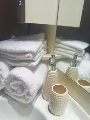 a bathroom with towels and a mirror and a sink at The Golden Embrace in Athens