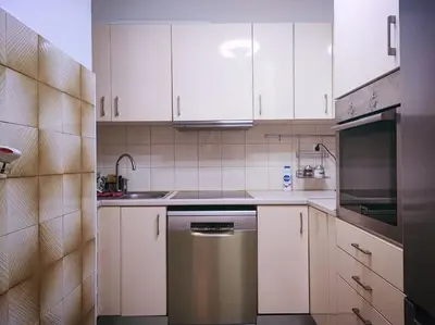 a kitchen with white cabinets and a stainless steel dishwasher at The Golden Embrace in Athens