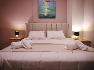 a bedroom with a large bed with towels on it at The Golden Embrace in Athens