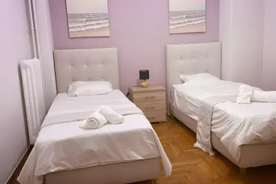 a bedroom with two beds with towels on them at The Golden Embrace in Athens