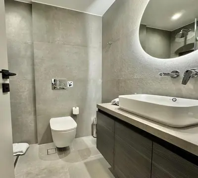 a bathroom with a sink and a toilet and a mirror at EN Suites Stylish & Comfort Stay near Acropolis in Athens