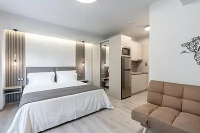 a bedroom with a large bed and a couch at EN Suites Stylish & Comfort Stay near Acropolis in Athens