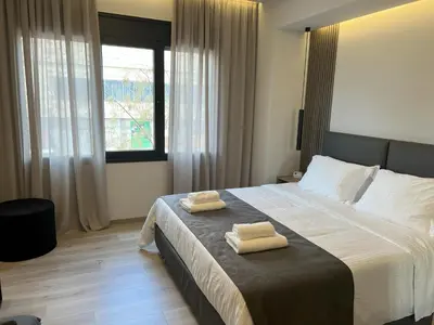 a bedroom with a large bed with two towels on it at EN Suites Stylish & Comfort Stay near Acropolis in Athens