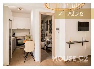 a kitchen with white cabinets and a table in a room at Athens House Concept Apartments in Athens