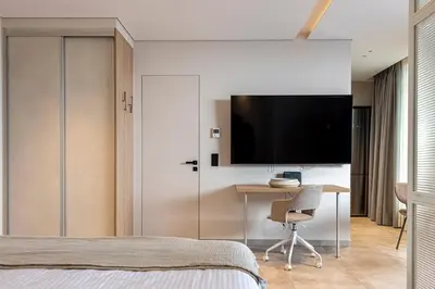 a bedroom with a desk and a tv on a wall at Phaedrus Living Athens Luxury Residences Sunstone in Athens