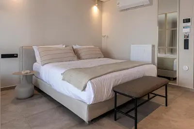 a bedroom with a large bed with a stool at Phaedrus Living Athens Luxury Residences Sunstone in Athens