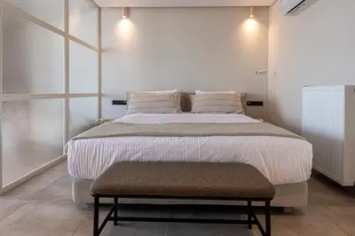 a bedroom with a large bed with a bench next to it at Phaedrus Living Athens Luxury Residences Sunstone in Athens