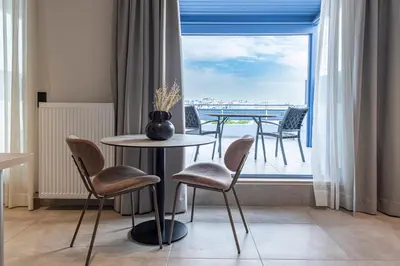 a room with a table and chairs and a balcony at Phaedrus Living Athens Luxury Residences Sunstone in Athens