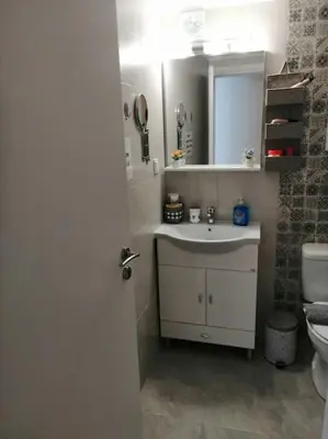 a bathroom with a sink and a mirror and a toilet at Acropolis Luxe Apartment in Athens