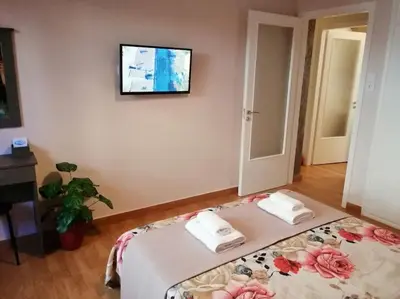 a bedroom with a bed with two towels and a tv on the wall at Acropolis Luxe Apartment in Athens