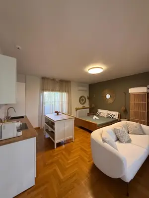 a living room with a couch and a bed at The Gardenian - 15 min from Athens Airport in Paianía
