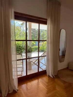 a room with a large glass door to a balcony at The Gardenian - 15 min from Athens Airport in Paianía
