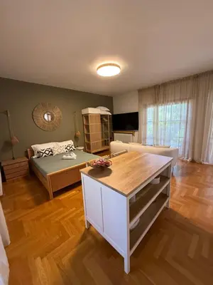 a living room with a bed and a couch at The Gardenian - 15 min from Athens Airport in Paianía