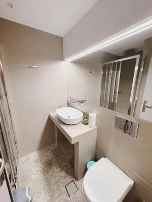 a white bathroom with a sink and a toilet at Minimal 2bd apartment in Thisio in Athens