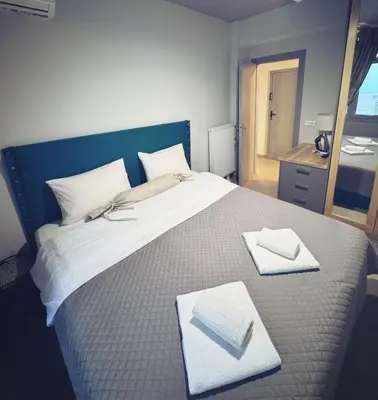 a large bed with two white towels on it at Minimal 2bd apartment in Thisio in Athens