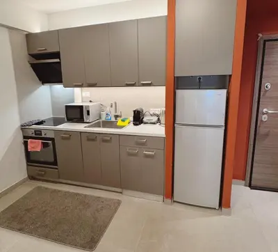a kitchen with gray cabinets and a white refrigerator at Minimal 2bd apartment in Thisio in Athens
