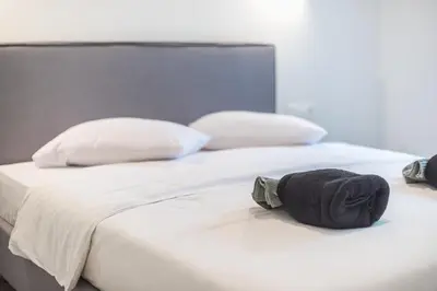 a bed with two pillows and two towels on it at Zen Glow, Neapoli in Athens