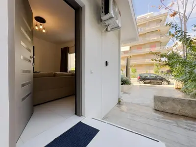 a hallway with a door leading to a living room at Terpsixoris cozy apartment in Paleo Faliro in Athens