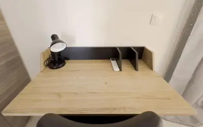 a wooden desk with a lamp and a chair at Terpsixoris cozy apartment in Paleo Faliro in Athens