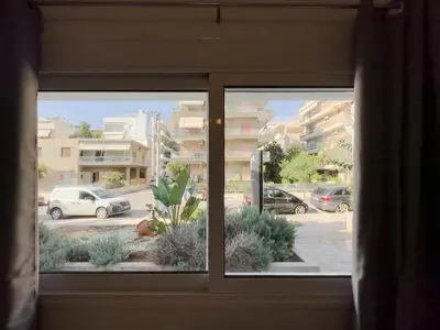 a window with a view of a parking lot at Terpsixoris cozy apartment in Paleo Faliro in Athens