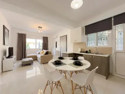 a kitchen and living room with a table and chairs at Terpsixoris cozy apartment in Paleo Faliro in Athens