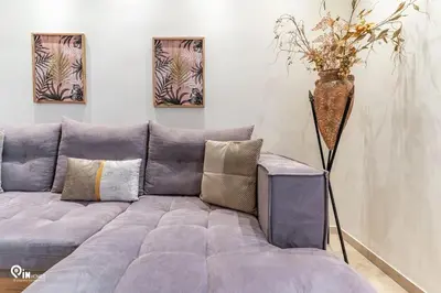 a purple couch in a living room with paintings on the wall at Golden Angel - Elegant Apartment in Egaleo-Athens in Athens