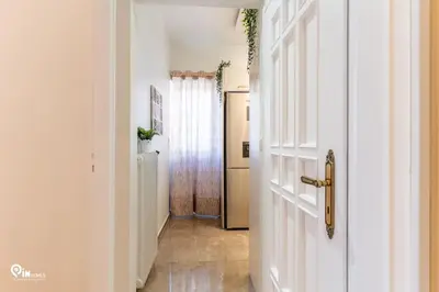 a hallway with a white door and a hallway with a refrigerator at Golden Angel - Elegant Apartment in Egaleo-Athens in Athens
