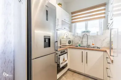 a stainless steel refrigerator in a small kitchen at Golden Angel - Elegant Apartment in Egaleo-Athens in Athens