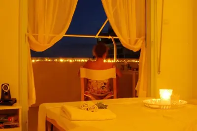 a woman sitting at a table looking out a window at Acropolis View Studio in Monastiraki in Athens