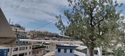 a tree in the middle of a city with buildings at Acropolis View Studio in Monastiraki in Athens