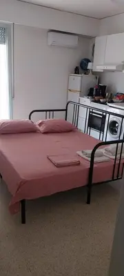 a bed in a small room with a kitchen at Acropolis View Studio in Monastiraki in Athens