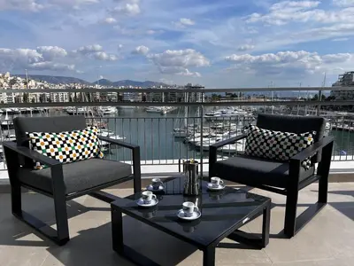 two chairs and a coffee table on a balcony with a harbor at Stunning View Zeas Marina - 1 bedroom in Piraeus