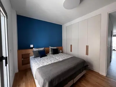 a bedroom with a large bed with a blue wall at Stunning View Zeas Marina - 1 bedroom in Piraeus