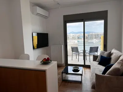 a living room with a couch and a table at Stunning View Zeas Marina - 1 bedroom in Piraeus