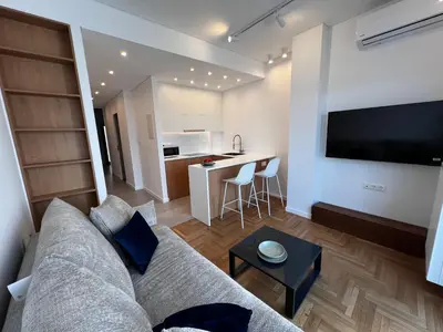 a living room with a couch and a small kitchen at Stunning View Zeas Marina - 1 bedroom in Piraeus