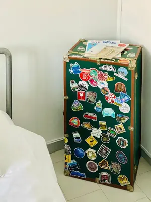 a refrigerator covered in stickers sitting next to a bed at Acropolis Penthouse with 50mbps WIFI in Athens